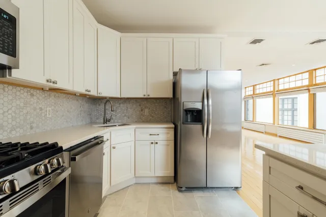 a kitchen with a refrigerator stove and cabinets