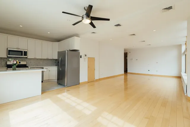 a view of a kitchen with a sink and a refrigerator