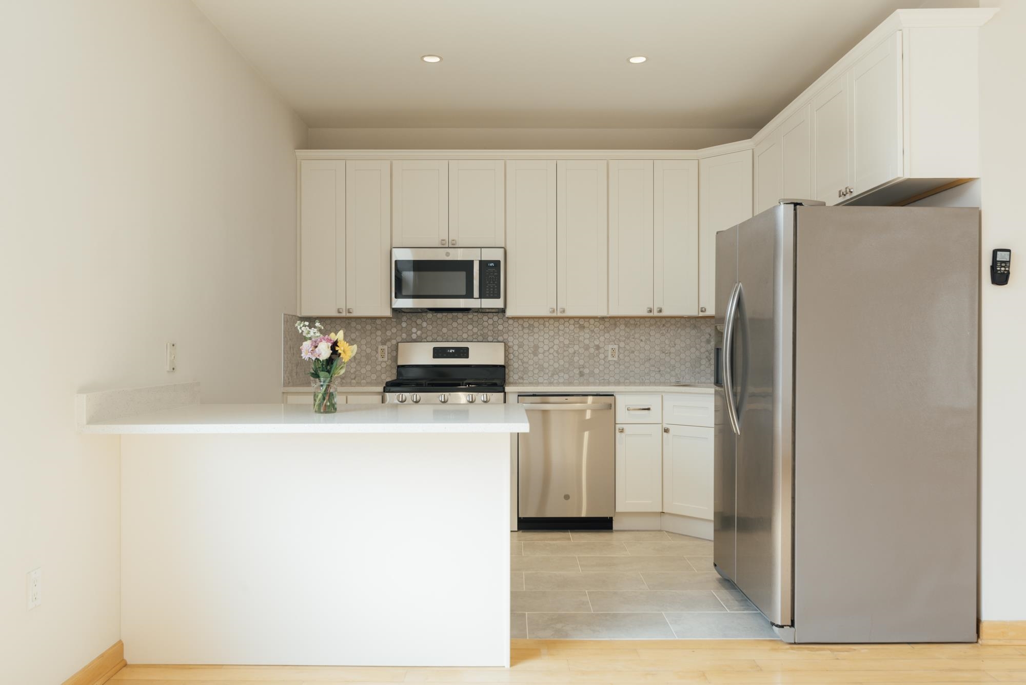 30 Park Avenue, Unit 2 Rutherford, NJ 07070 - Photo 8 of 34 a kitchen with a refrigerator a stove top oven and white cabinets