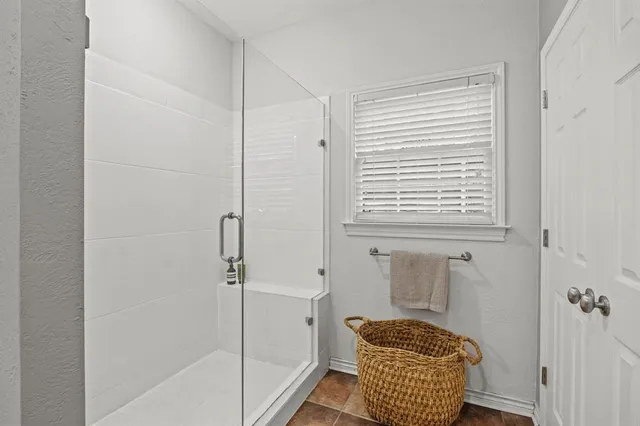 a bathroom with a window and a shower