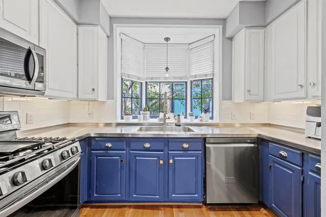 a kitchen with stainless steel appliances granite countertop a sink stove and cabinets