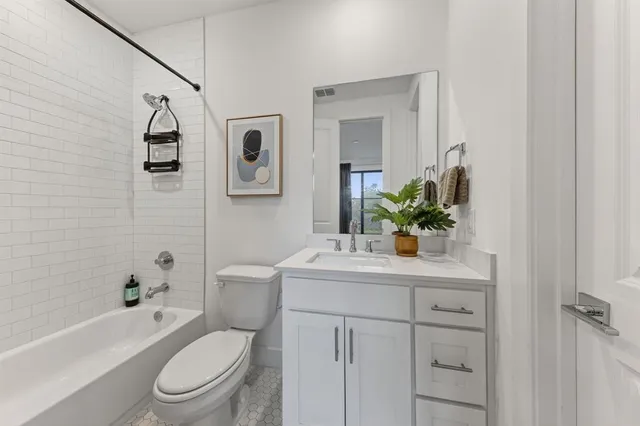 a bathroom with a toilet sink vanity tub and mirror