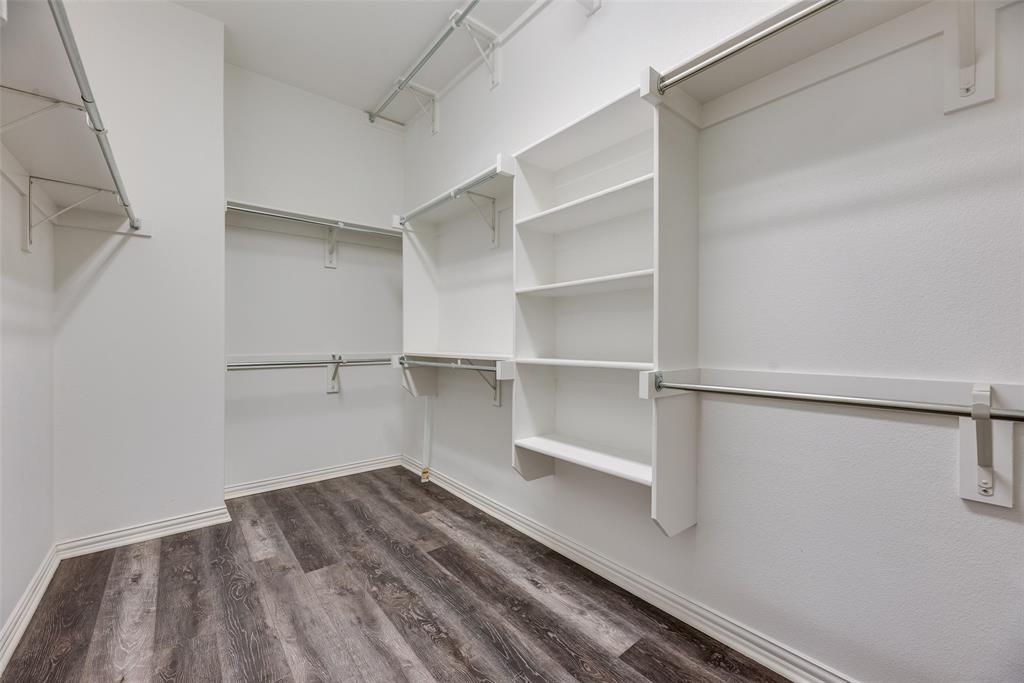 4670 I Rhett Lane, Unit I Carrollton, TX 75010 - Photo 14 of 31 Walk-in closet featuring wood-finish flooring, built-in shelving, and multiple hanging rods