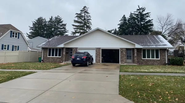 a view of a house with a yard and large trees