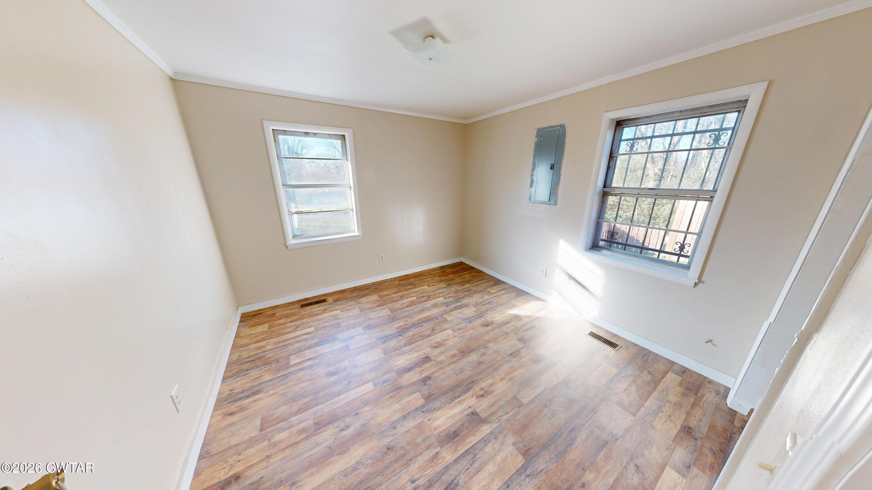 322 Jones Street Newbern, TN 38059 - Photo 18 of 22 a view of an empty room with wooden floor and a window