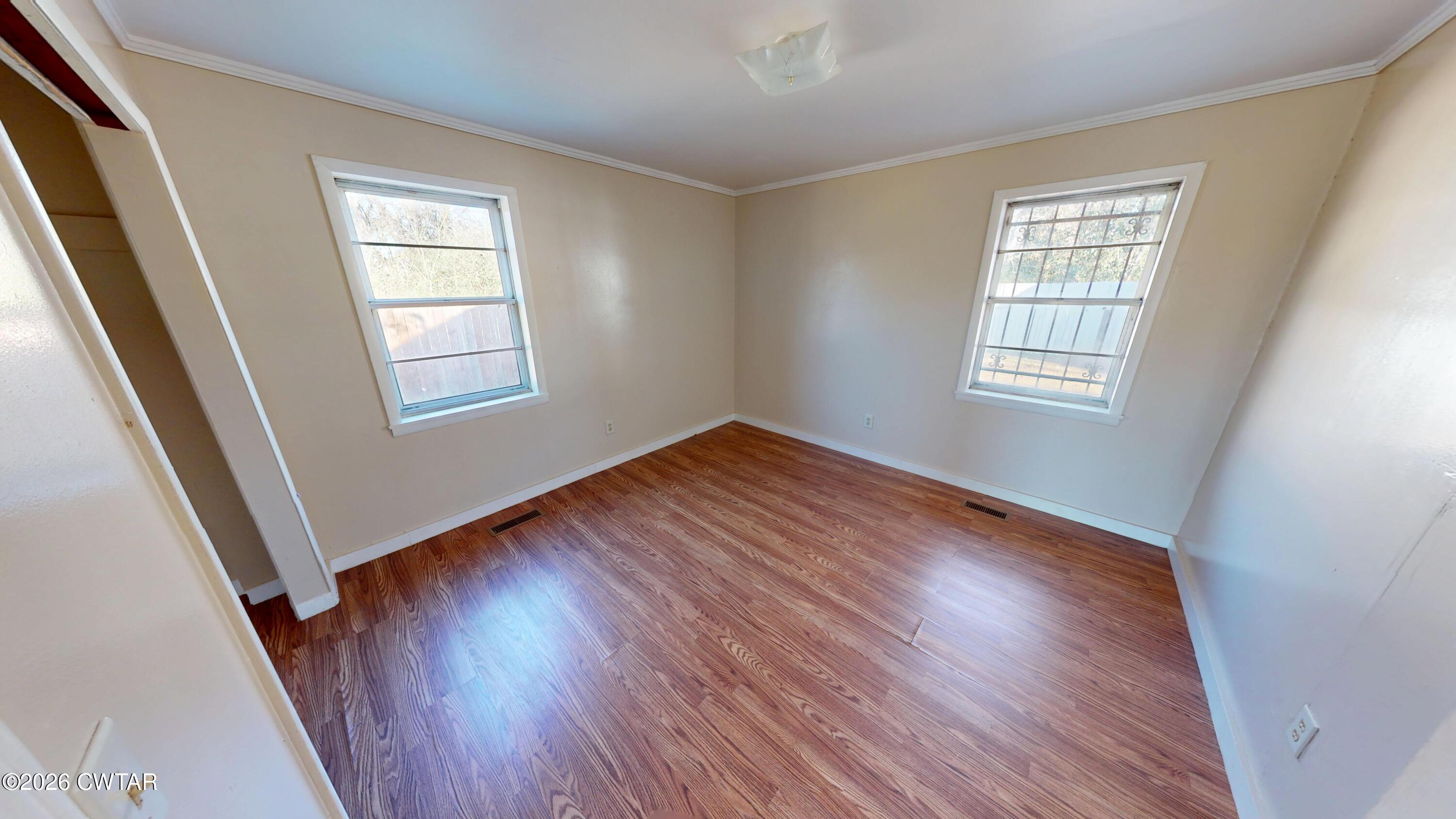 322 Jones Street Newbern, TN 38059 - Photo 19 of 22 a view of an empty room with wooden floor and a window