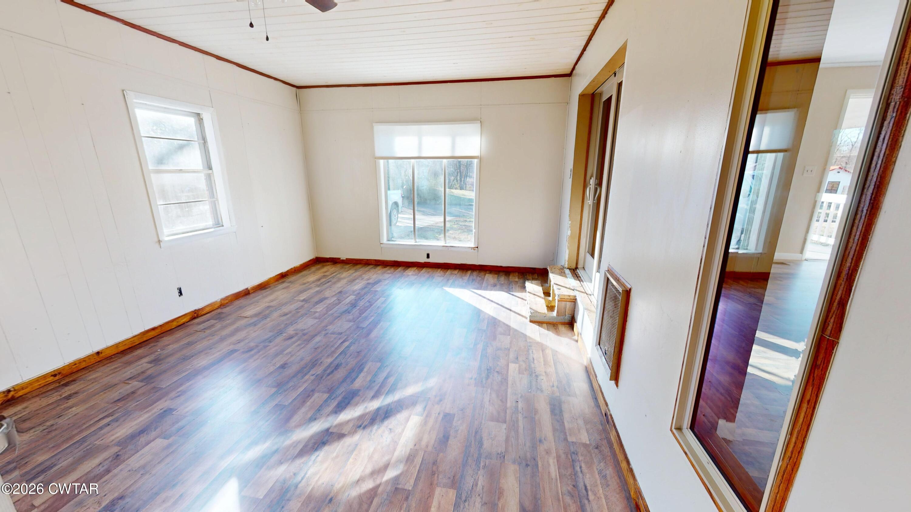322 Jones Street Newbern, TN 38059 - Photo 5 of 22 an empty room with wooden floor and windows