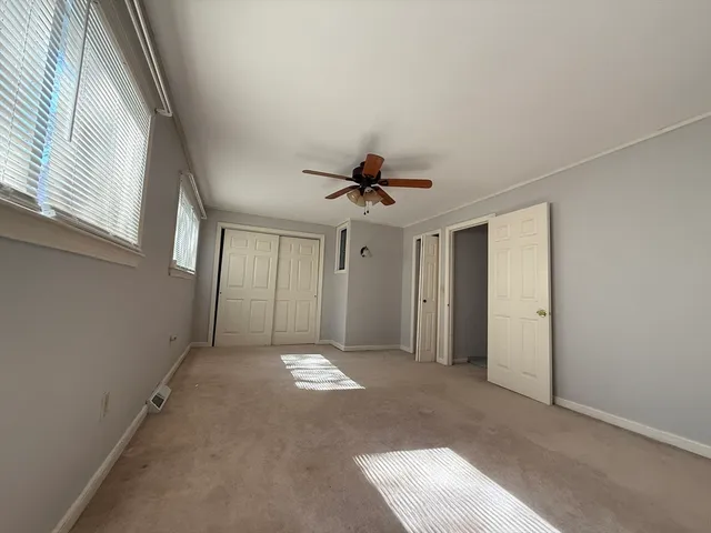 a view of a livingroom with a ceiling fan and window