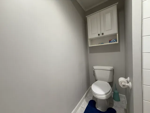 a white toilet sitting next to a white cabinet