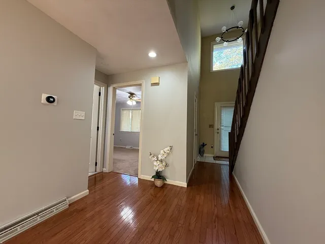 a view of a hallway with wooden floor and stairs