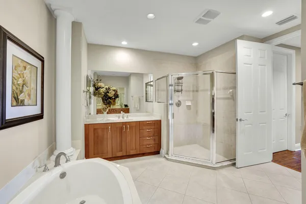 a bathroom with a tub a sink and mirror