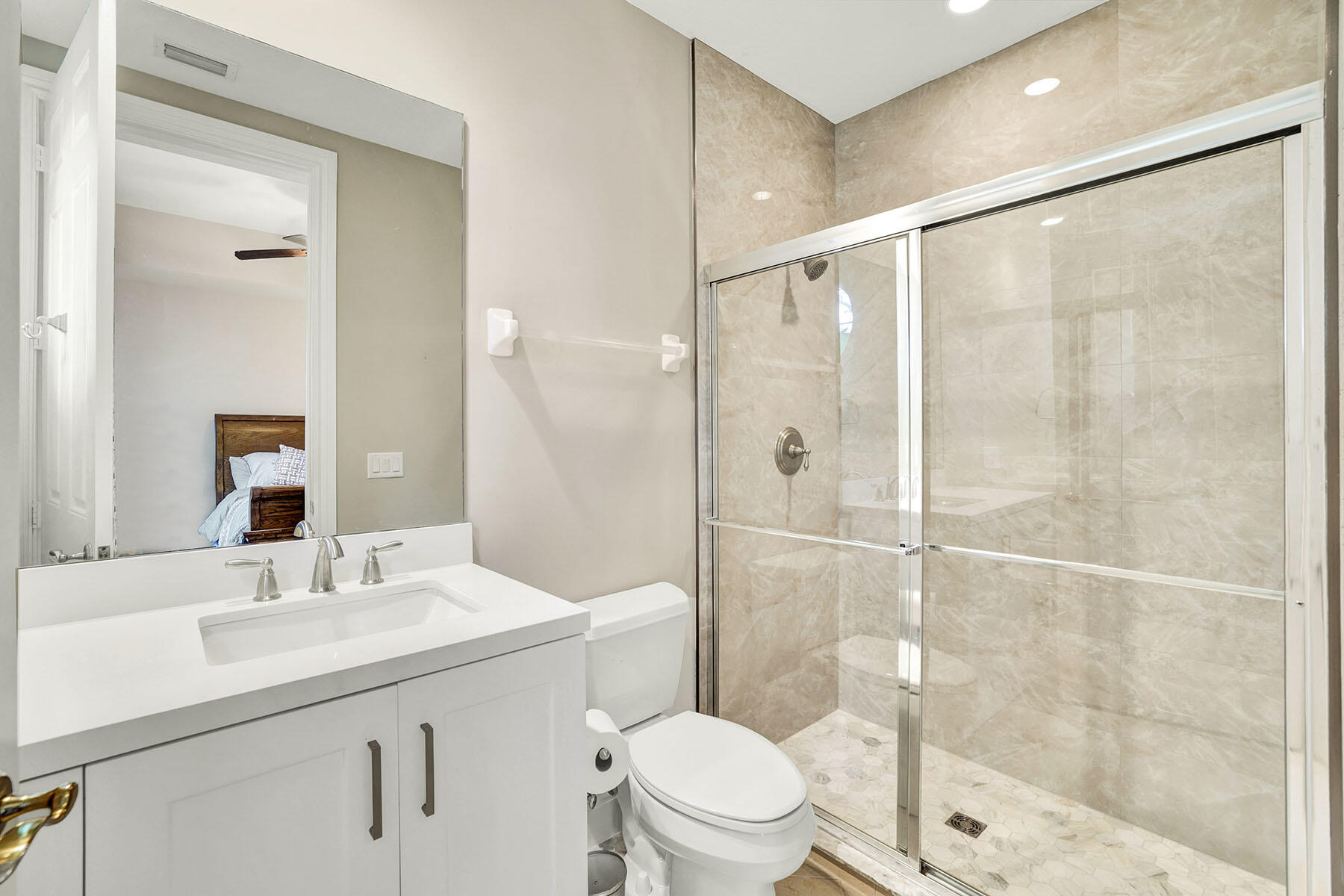 9234 Tesoro, Unit 101 Naples, FL 34114 - Photo 22 of 25 a bathroom with a shower sink vanity mirror and toilet