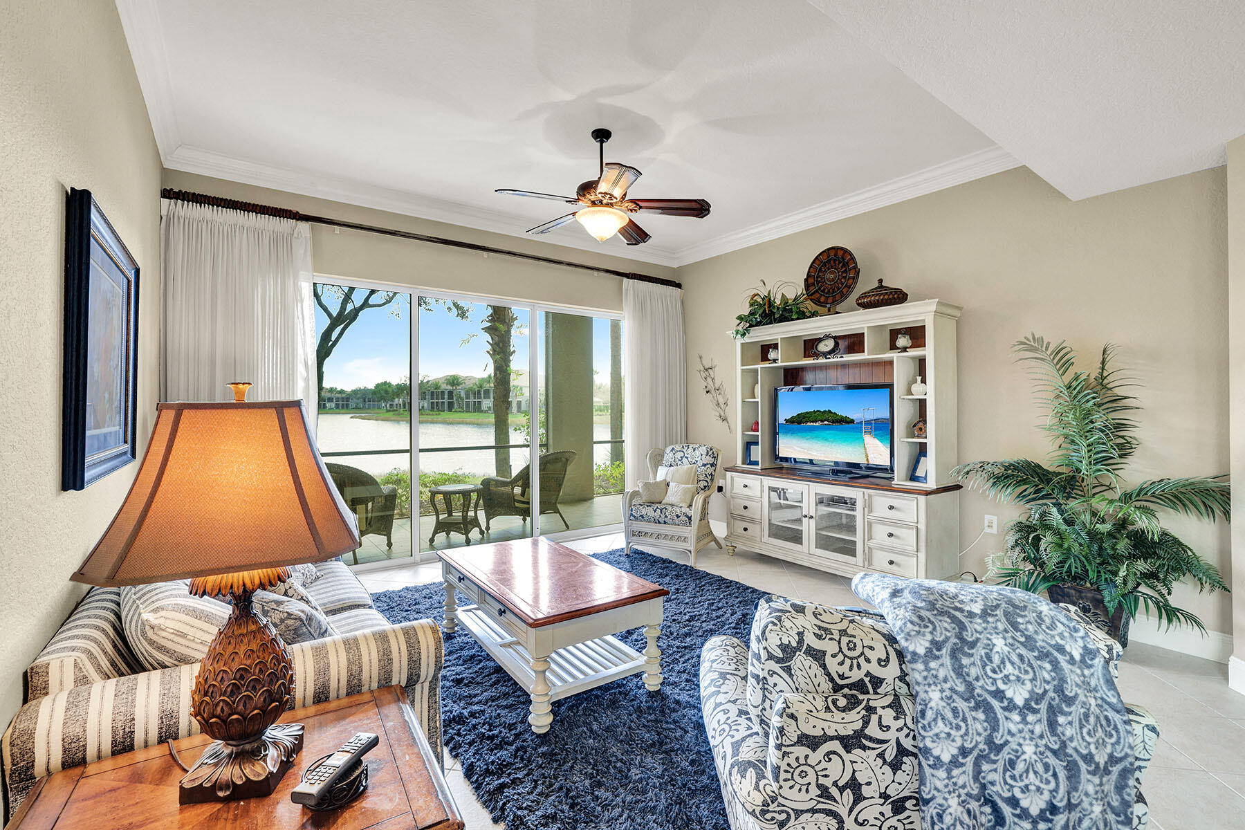 9234 Tesoro, Unit 101 Naples, FL 34114 - Photo 6 of 25 a living room with furniture a flat screen tv and a large window