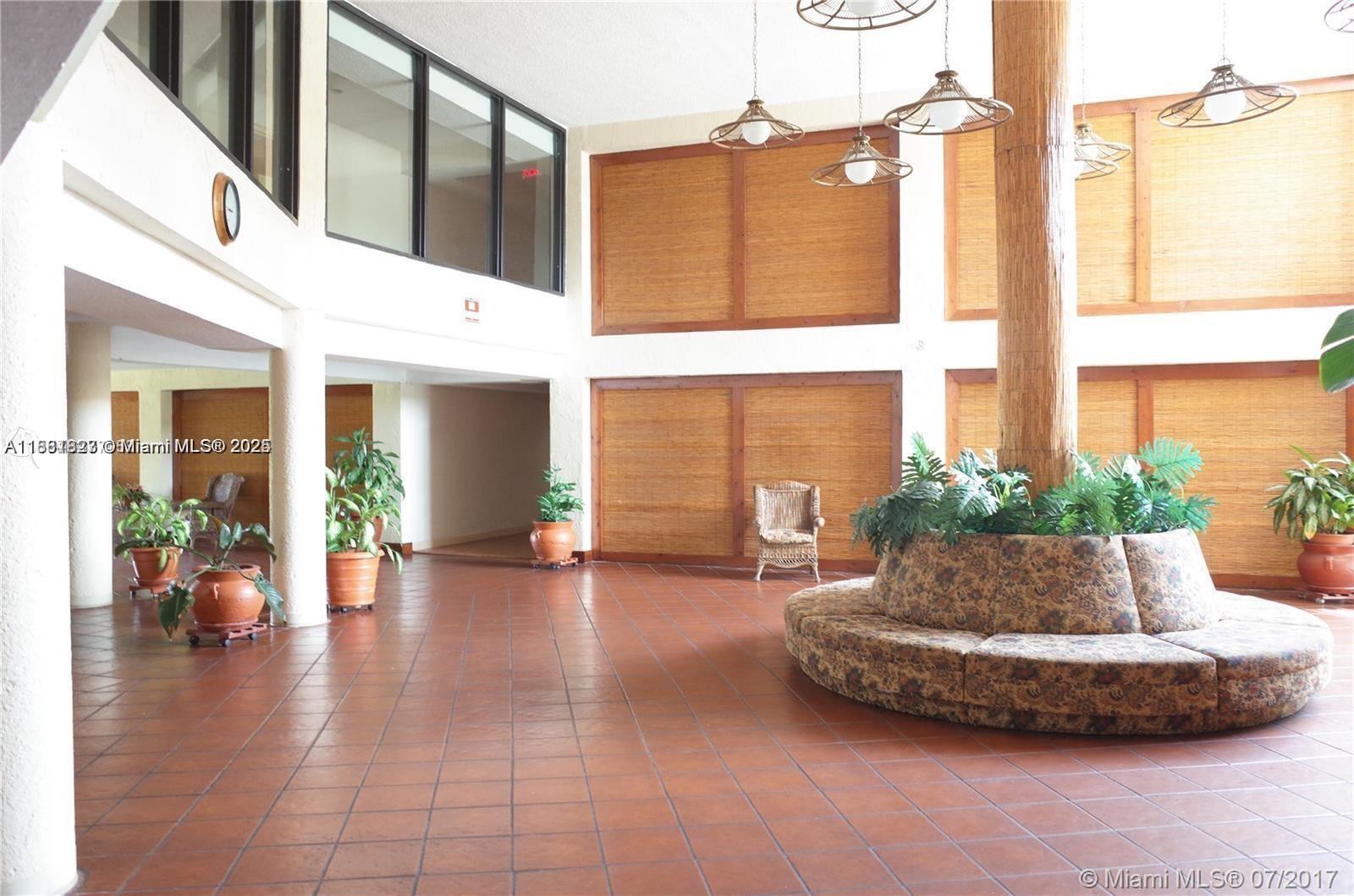 1300 Southwest 122nd Avenue, Unit 4072 Miami, FL 33184 - Photo 4 of 11 a view of a building with potted plants and couches