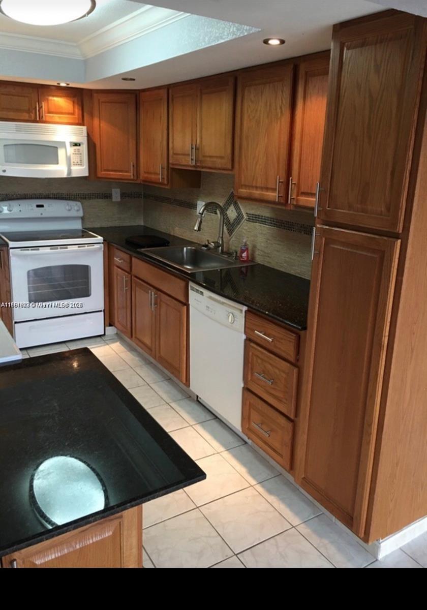 1300 Southwest 122nd Avenue, Unit 4072 Miami, FL 33184 - Photo 7 of 11 a kitchen with a sink and a stove