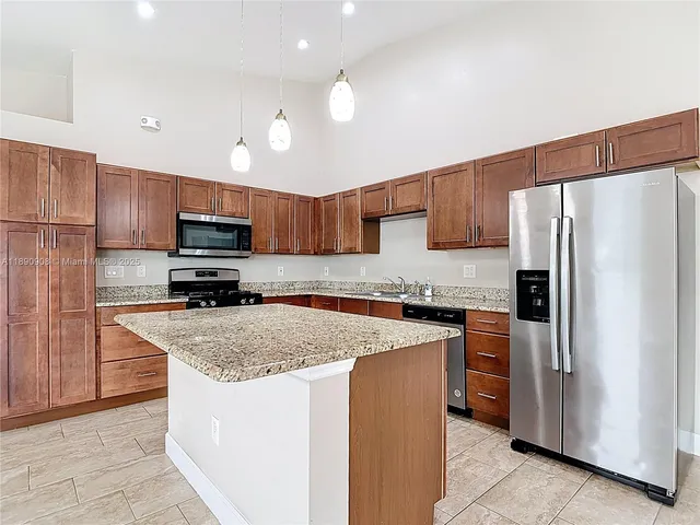a kitchen with stainless steel appliances granite countertop a refrigerator stove microwave sink and cabinets