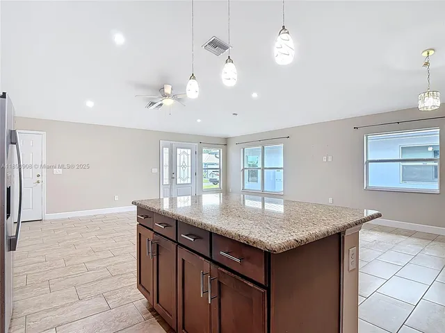 a kitchen with granite countertop a sink cabinets and window