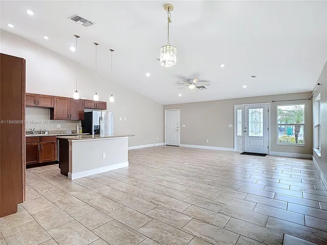a large kitchen with kitchen island a sink stainless steel appliances and cabinets