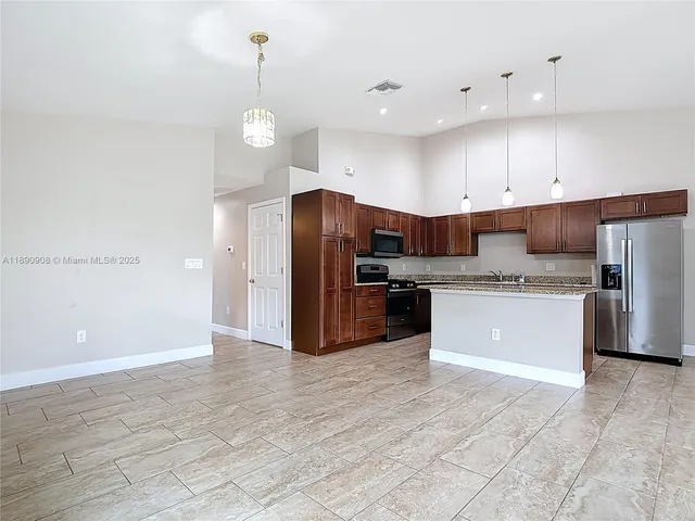 a kitchen with stainless steel appliances a refrigerator sink and cabinets