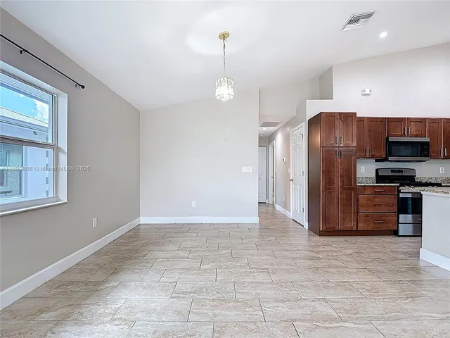 a kitchen with stainless steel appliances granite countertop a refrigerator and a sink