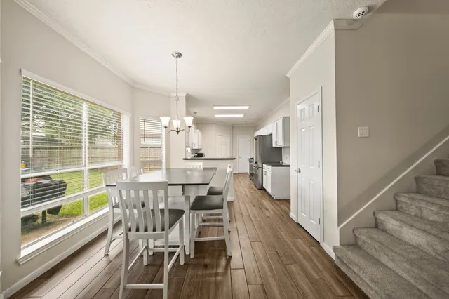 a view of a dining room and livingroom with furniture wooden floor a chandelier