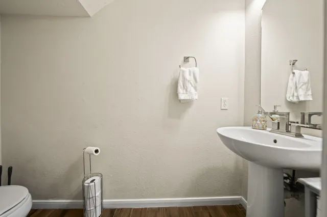 a bathroom with a sink a toilet and mirror