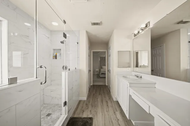 a bathroom with a double vanity sink mirror and shower