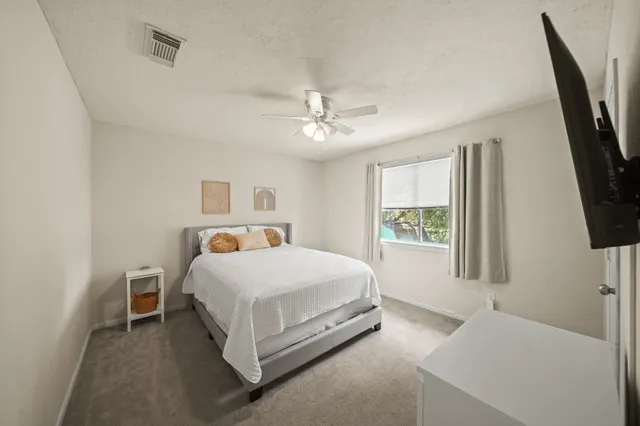 a bed room with a bed tv and a window