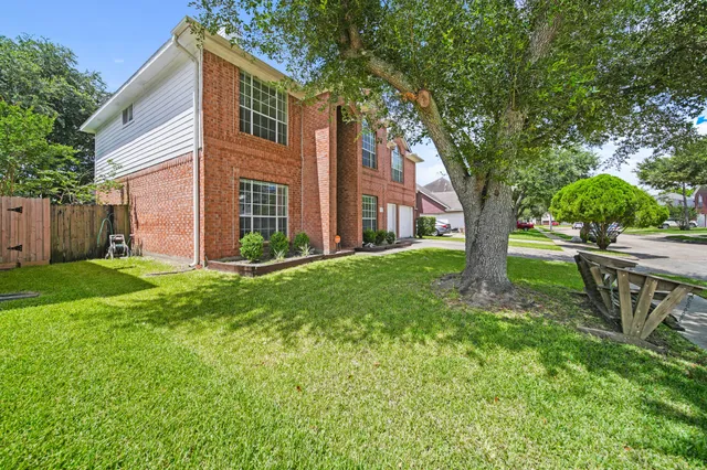 a view of a house with backyard and a tree