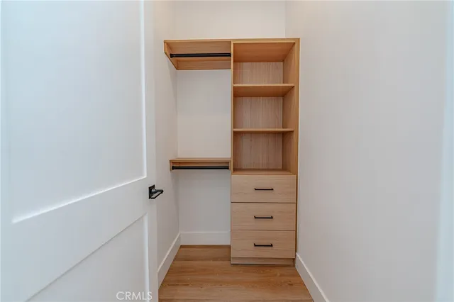 a view of walk in closet with empty racks