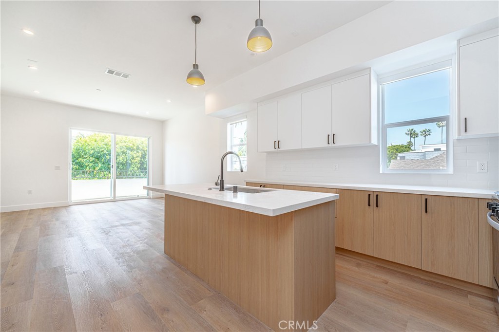 614 1/2 North Rampart Boulevard, Unit 1/2 Silver Lake, CA 90026 - Photo 16 of 41 a kitchen with kitchen island granite countertop a sink a counter space and windows