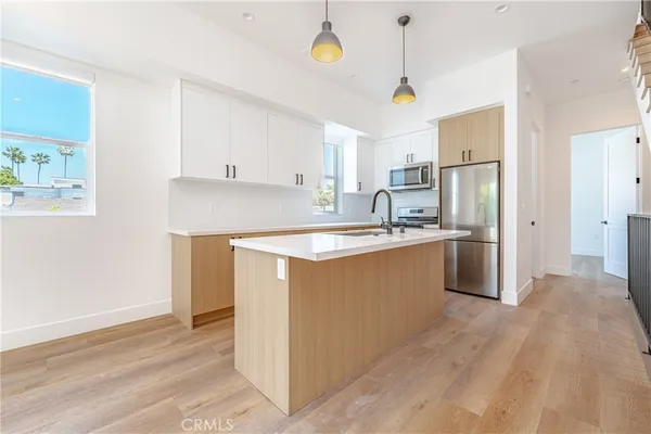 a kitchen with a refrigerator sink and cabinets