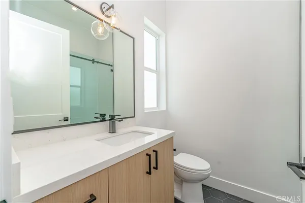 a bathroom with a sink a toilet and mirror