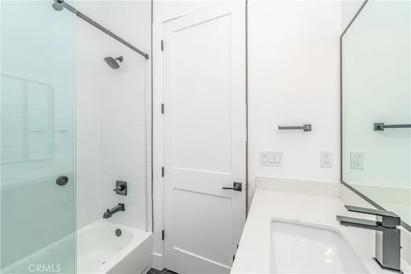 a bathroom with a tub shower and vanity