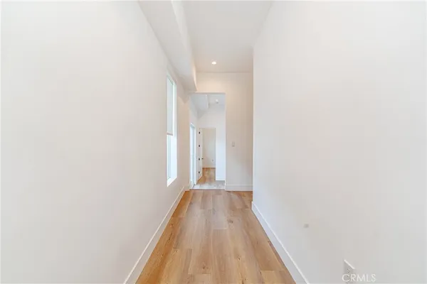 a view of a hallway with wooden floor