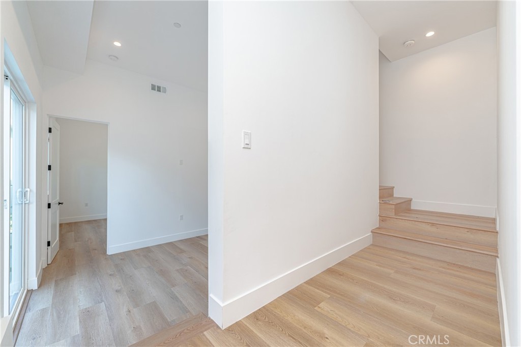 614 1/2 North Rampart Boulevard, Unit 1/2 Silver Lake, CA 90026 - Photo 9 of 41 a view of an empty room with wooden floor and a hallway