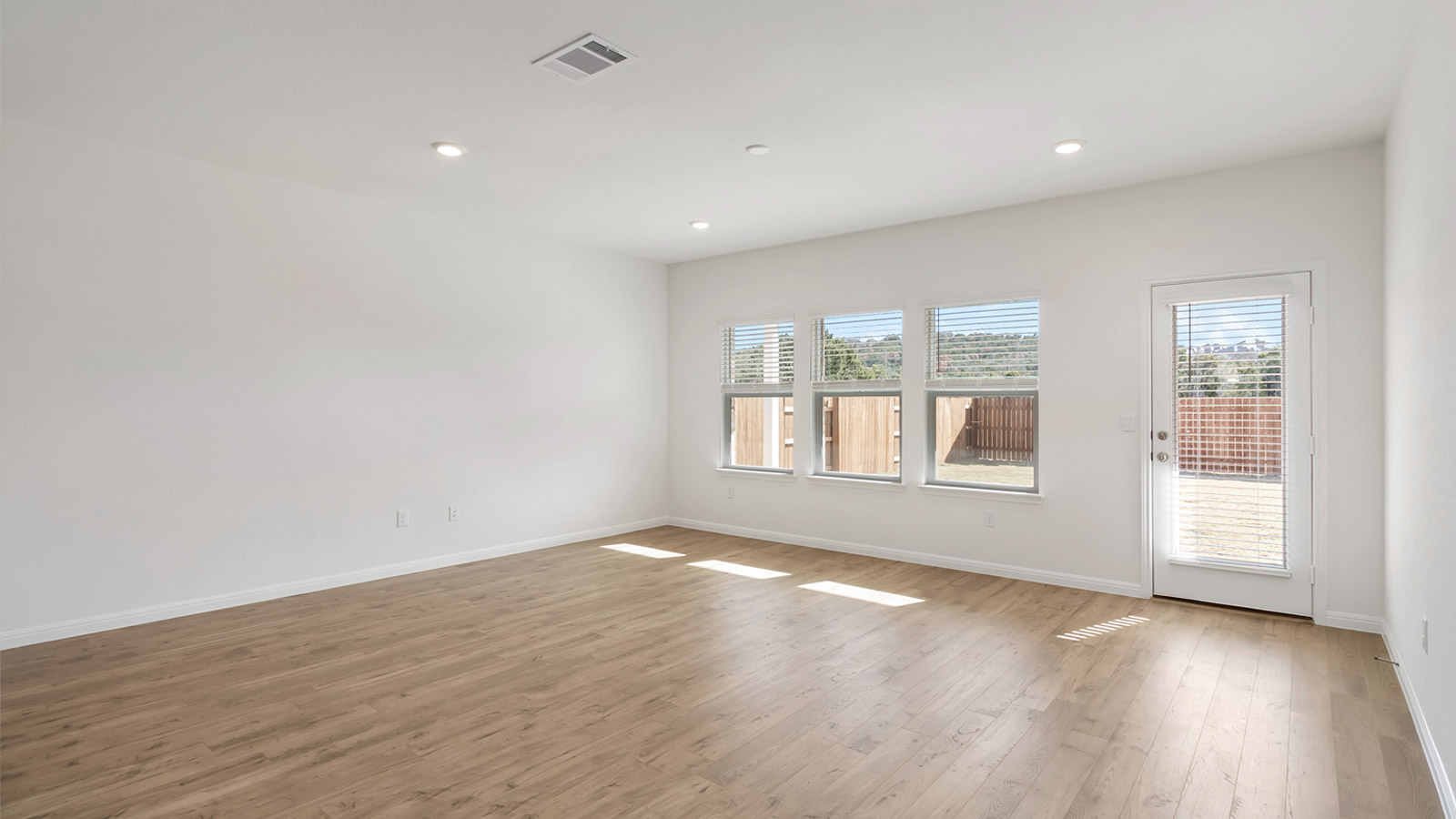 2560 Whittler Road Leander, TX 78641 - Photo 7 of 30 a view of an empty room with a window and wooden floor