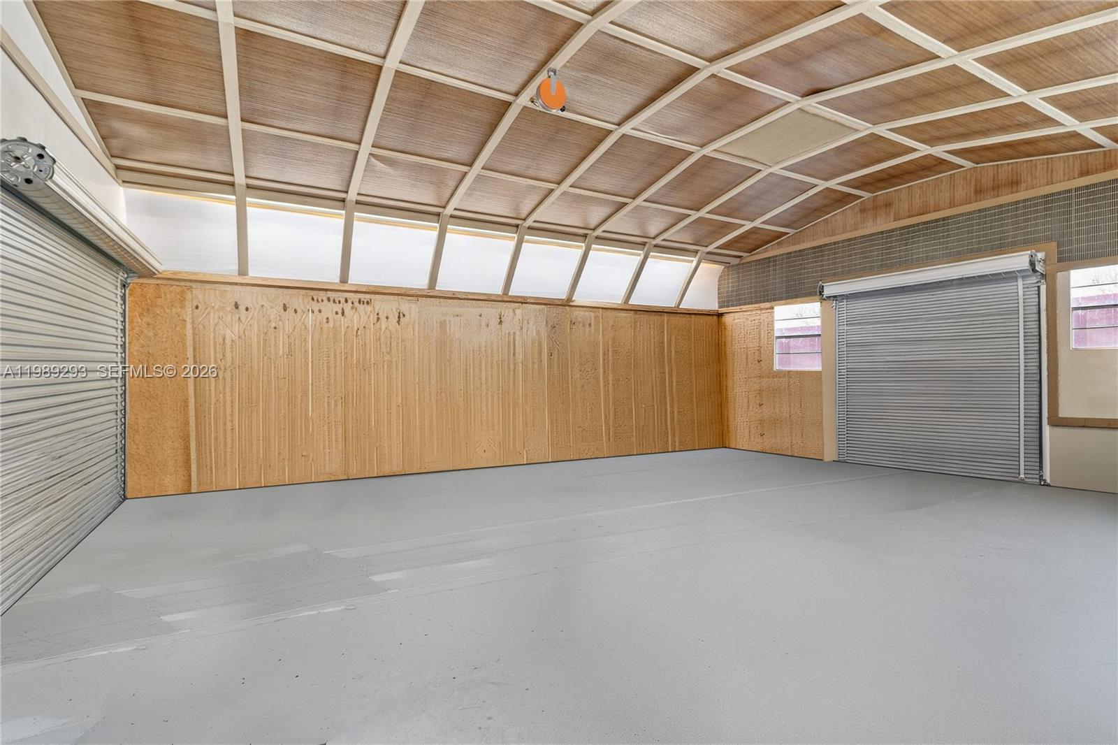 8435 Northwest 6 Avenue Gainesville, FL 32607 - Photo 18 of 52 720 sf Workshop with two sets of rolling metal doors. This interior photo has been photoshopped to remove contents.