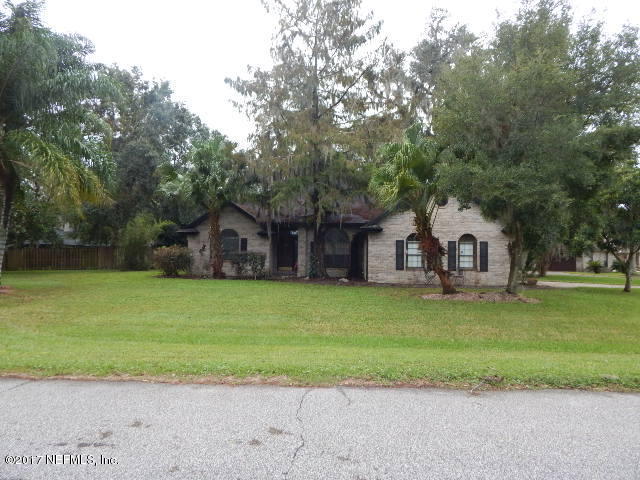 3133 Nautilus Road Middleburg, FL 32068 - Photo 1 of 17 a front view of a house with a garden and trees