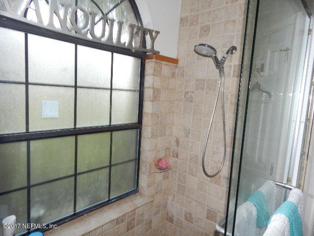 3133 Nautilus Road Middleburg, FL 32068 - Photo 12 of 17 a bathroom with a glass shower door