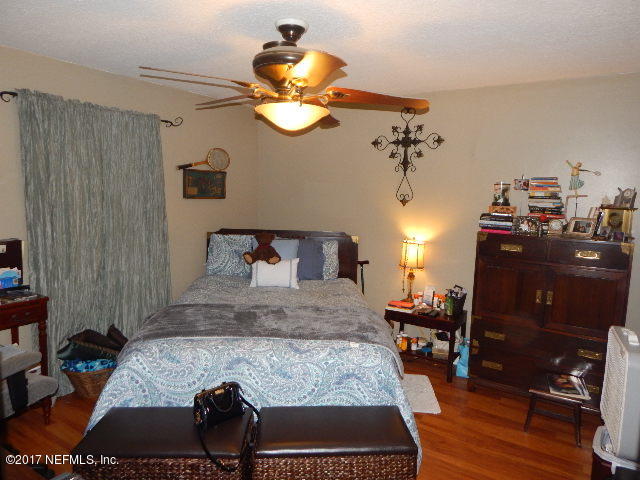 3133 Nautilus Road Middleburg, FL 32068 - Photo 9 of 17 a bedroom with a bed and wooden floor