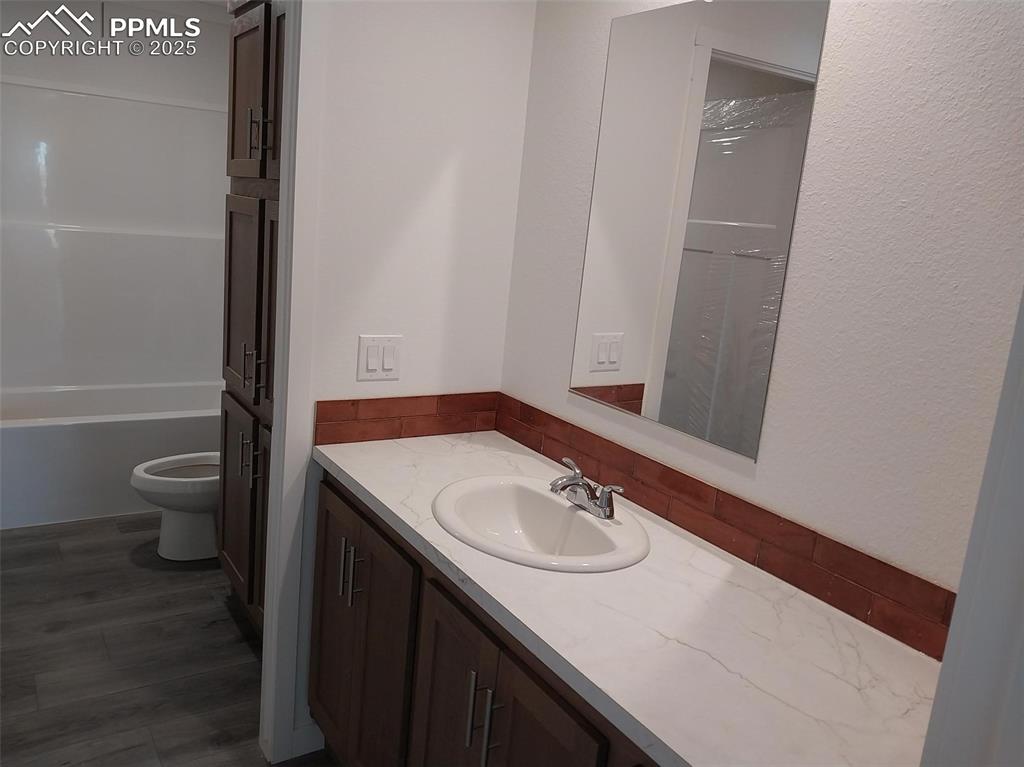 654 North Ramah Highway Yoder, CO 80864 - Photo 17 of 25 Bathroom with vanity, a closet, and dark wood-style flooring