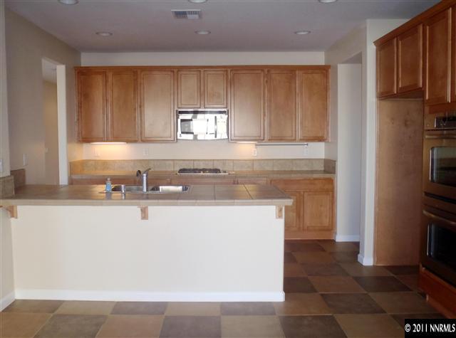 14045 Tagor Road Reno, NV 89521 - Photo 6 of 13 a kitchen with stainless steel appliances granite countertop a sink stove and refrigerator