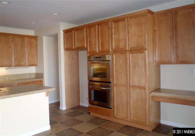 14045 Tagor Road Reno, NV 89521 - Photo 7 of 13 a view of a refrigerator in kitchen and wooden cabinets