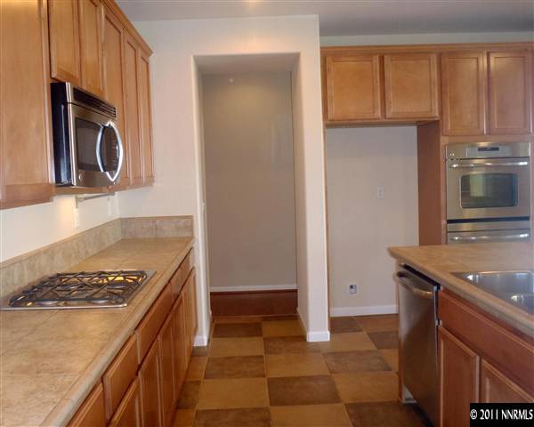 14045 Tagor Road Reno, NV 89521 - Photo 8 of 13 a kitchen with stainless steel appliances granite countertop a stove a microwave and a refrigerator