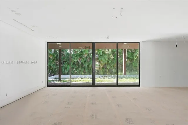 a view of an empty room with large windows