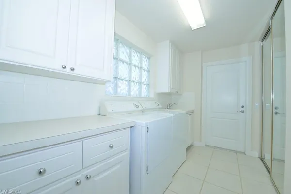 a utility room with cabinets washer and dryer