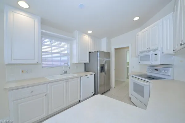 a kitchen with stainless steel appliances a refrigerator sink and cabinets