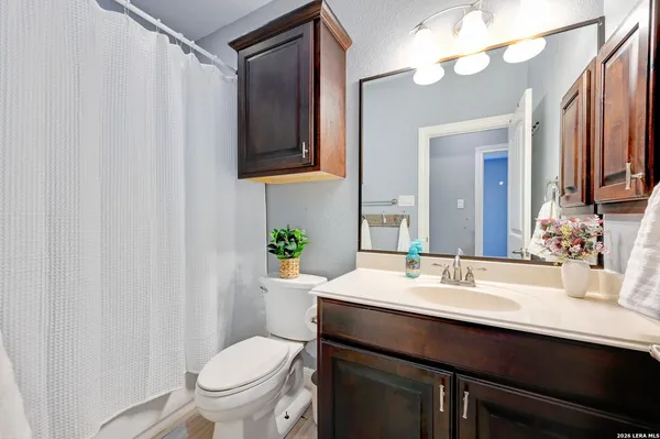 a bathroom with a sink vanity mirror and toilet