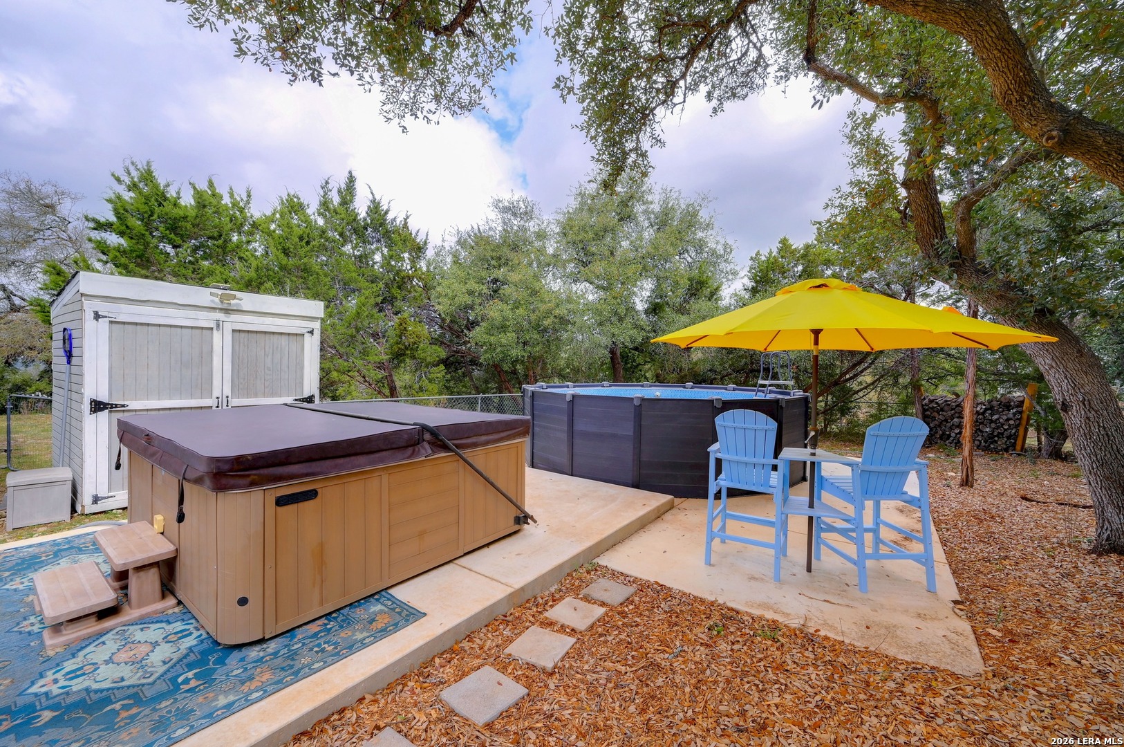 1134 Victoria Spring Branch, TX 78070 - Photo 21 of 28 a backyard of a house with table and chairs under an umbrella